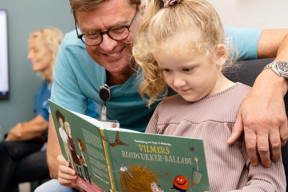 Billede af mand, der læser højt for barn